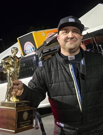 Paul Miller holding an IHRA winner's trophy