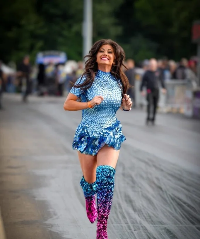 Shannon Hill as Mad Maxine, running down the track in blue sequins and boots